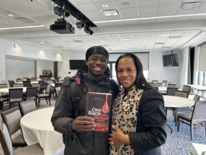 two people standing and holding a book