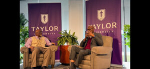 two men sitting in chairs, talking